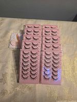 multiple trays of synthetic false eyelashes in pink holders