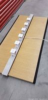 Lighting bar lying on tatami mat showing six light heads and beam