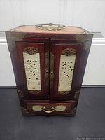 Front view showing wood exterior, jade panels, brass fittings