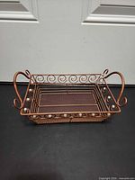 Angled view showing front, side scrollwork, faux pearls, and dual handles