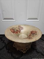 Top view of bird bath showing grape motif and basin wear