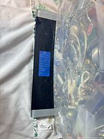 Plastic bin containing mix of jewelry items next to digital scale