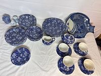 Overview of entire dinnerware set laid out on cloth