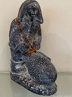 Full view of soapstone Inuit fisherman holding fish