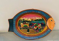 Front view of fish-shaped plate showing full painted scene and border
