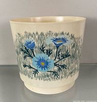 Front view of beige plastic planter showing blue floral print