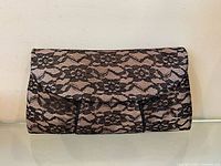 Front view of clutch purse showing lace overlay and flap design