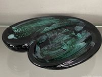 Top view of kidney-shaped dish showing green drip glaze pattern