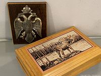 Overall view of both items: eagle plaque standing upright, moose engraved wood box closed