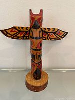 Front view of carved wood totem pole showing full design and base
