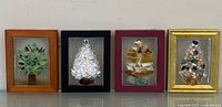 Front view of four framed glass and pebble tree artworks