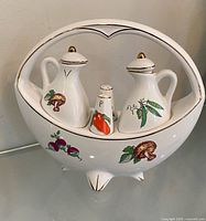Front view of complete caddy set showing two cruets, shaker and vegetable motifs