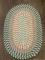 Full view of oval braided jute rug on wood floor