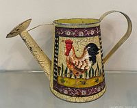 Front view showing rooster motif, spout, handle, crackle finish