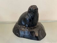 Front left view of soapstone seal sculpture on rock base