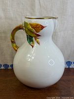 Full side view of pitcher showing body, handle and decoration