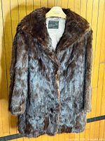 Full view of the brown beaver fur coat on hanger