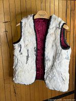 Vest front showing white rabbit fur, grey markings, burgundy satin lining, black trim