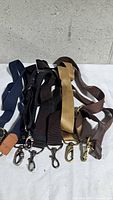 Group of six assorted canvas shoulder straps showing colours, hardware, adjusters