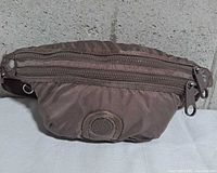 Front view showing Kipling logo patch and dual zippered compartments