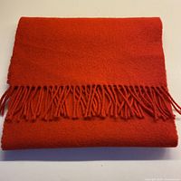 Folded red scarf showing fringe detail