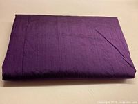 Folded length of deep purple silk fabric