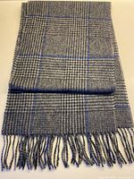 Full view of folded scarf showing checked pattern and fringe