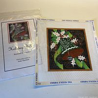 Canvas in protective sleeve with stitch guide booklet visible, branding and design name shown