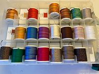 Top view of first tray row of Madeira thread spools showing colour variety and plastic case compartments