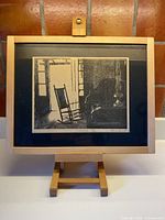 Framed woodcut print on easel, full view with frame and matte
