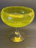 Full view of vaseline glass bowl on clear stem and foot