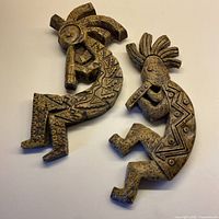 Both concrete flute player wall plaques displayed front view