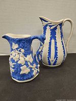 Both blue and white Parian pitchers side by side