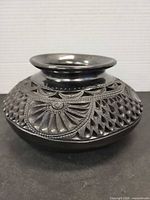 Front angled view showing carved and openwork pattern on vase body