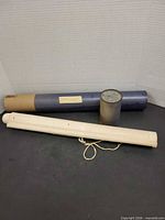 Three cylindrical storage containers: blue tube, white tube with string, Parafilm M canister