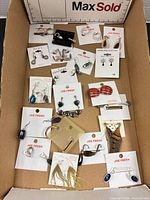Overview of entire lot of carded earrings in box