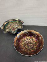 Both amethyst carnival glass bowls side by side showing patterns and scalloped rims