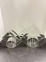 Front view of both clear glass pyramid oil lamp holders showing size difference