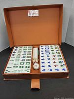 Open case showing all tile stacks, dice and marker