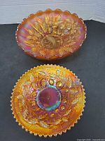 Both carnival glass pieces showing size and patterns