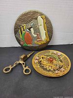 Group shot of filigree plate, painted plaque front, brass wick trimmer
