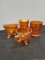 All four marigold carnival glass pieces