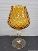 Full view of amber glass snifter vase showing overall shape and color