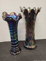 Both amethyst iridescent carnival glass vases side by side