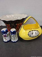 Group view of yellow basket, salt and pepper shakers, red black pot