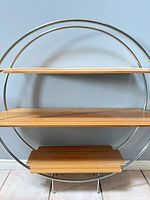 Full view of circular metal frame shelf with three bamboo wood veneer tiers
