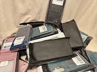 Pile of packaged phone wallet cases in various colours