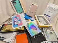 Pile of packaged phone cases and screen protectors in various colours and materials