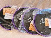Four sealed sets of purple-rimmed black core sliders in packaging