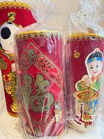 Three red cylindrical decorations wrapped in plastic